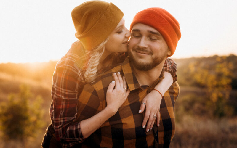 Cheerful guy and girl on a walk in bright knitted hats Cheerful guy and girl on a walk in bright knitted hats and plaid shirts